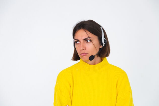 客户穿黄色毛衣的漂亮女人戴着白经理的耳机不开心累无聊争论愤怒女性