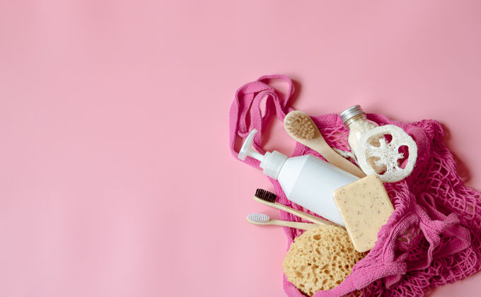 粉色平铺温泉组成与个人卫生用品和浴室配件在一个字符串袋护理合成配件