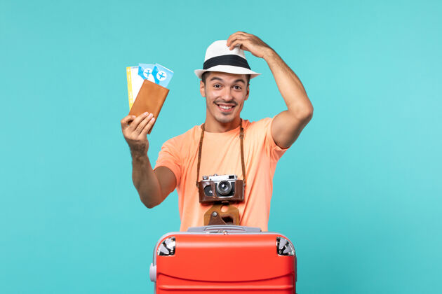 假期正面图：男人在度假 手里拿着他的票 脸上挂着蓝色的微笑蓝色航行举行