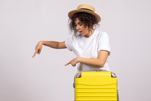 飞行正面图年轻女性带着黄包准备乘坐白色背景的旅行度假飞机航行彩色休息航班旅游者年轻女性肚子休息