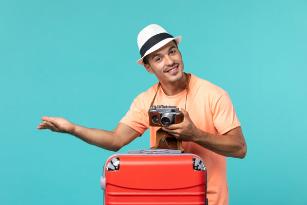 假期带着红色手提箱和蓝色相机的度假男人男人旅程相机