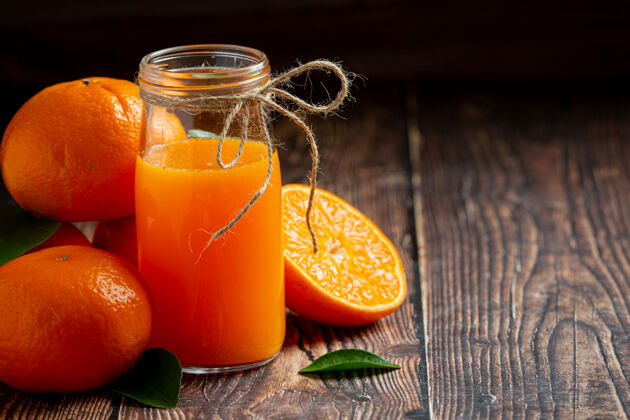 玻璃杯新鲜的橙汁在黑暗的木制背景玻璃一半木头桌子