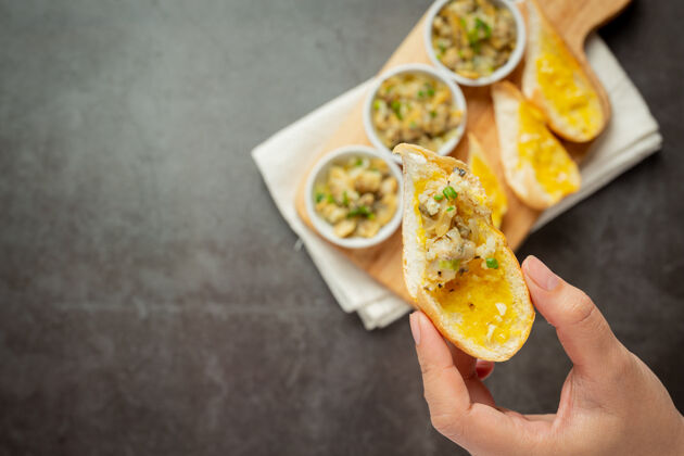 烘焙烤蛤蜊配大蒜和黄油 配大蒜面包 背景颜色为深色吐司新鲜特写