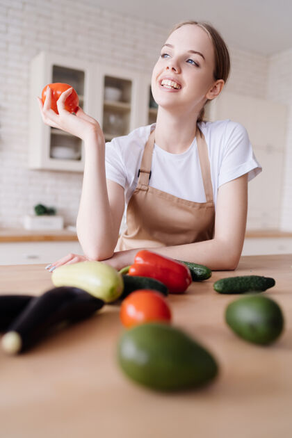 年轻年轻漂亮的女人在厨房里围着围裙 桌上放着新鲜的蔬菜健康美味女性