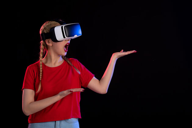女士年轻女性在黑暗的墙上玩虚拟现实的正面图黑暗游戏正面