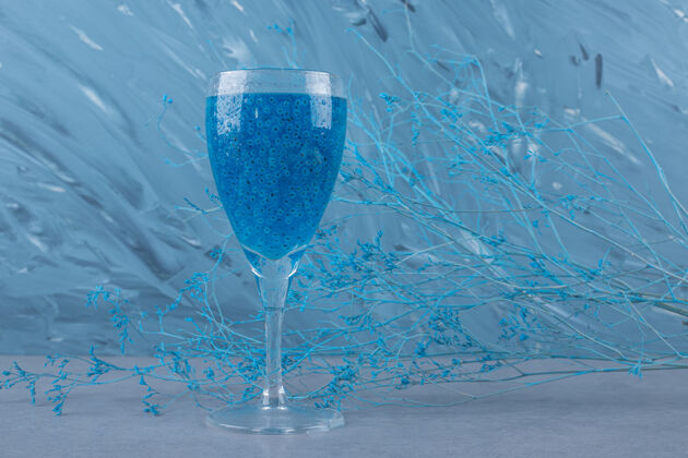 朗姆酒一杯新鲜的蓝色鸡尾酒在灰色的表面上玻璃冷冻利口酒