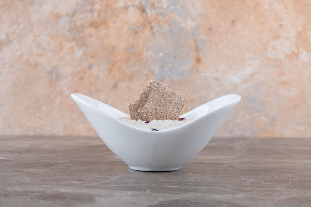 牙粉石榴皮放在粥里的盘子里 放在大理石的表面健康燕麦粥