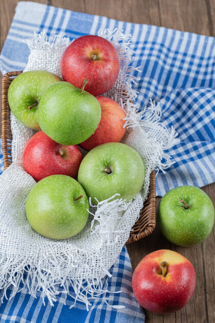 清淡红色和绿色的苹果被隔离在蓝色格子毛巾上热带多汁酸