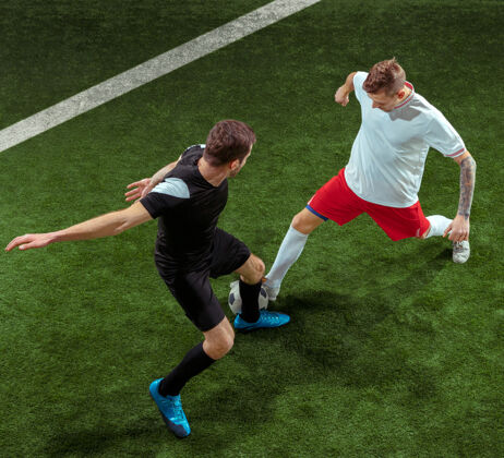 踢足球运动员在草地上抢球制服战斗球员