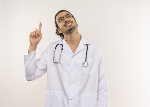 复制仰望微笑的年轻男医生 戴着眼镜 穿着白袍 用听诊器指向上眼镜男性医生