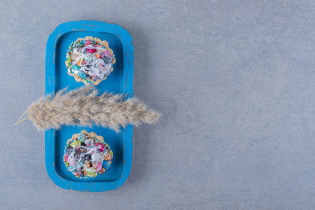 咬新鲜多彩的自制饼干放在蓝色木板上块脆运动