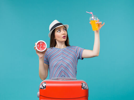 果汁前景度假女人拿着果汁和蓝色背景上的钟远航度假海上旅行旅程女人举行肖像女性