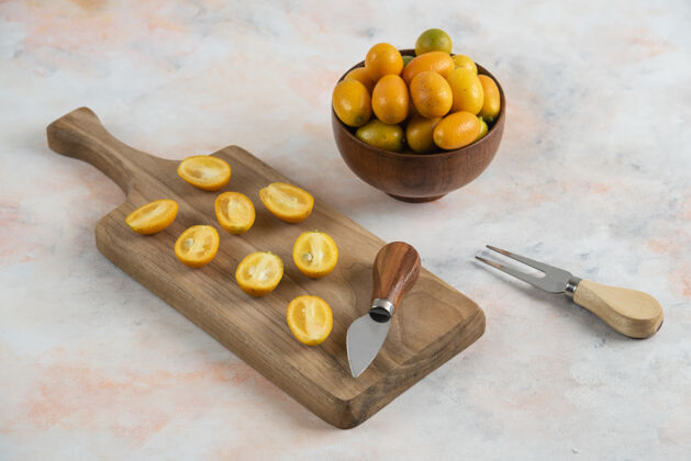柑橘整个金橘放在碗里 半个金橘放在木砧板上小健康成熟