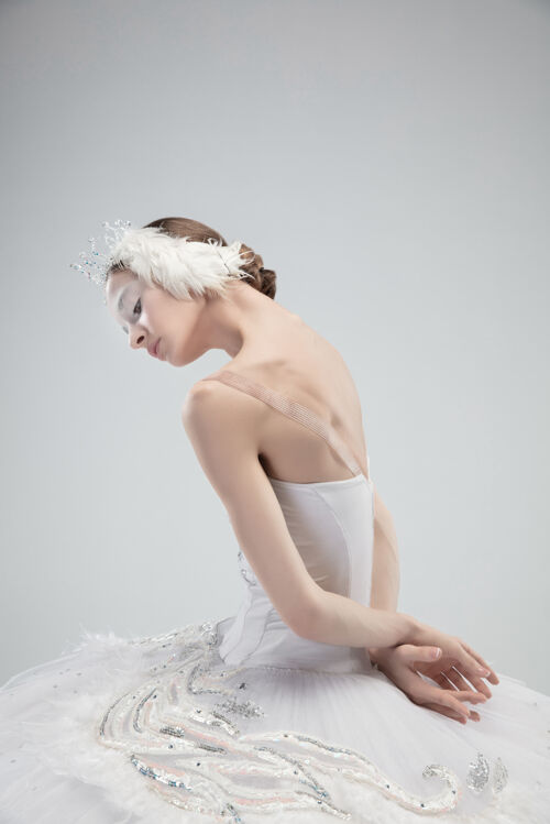 表演白色工作室背景上年轻优雅的芭蕾舞演员的特写镜头动作优雅平衡
