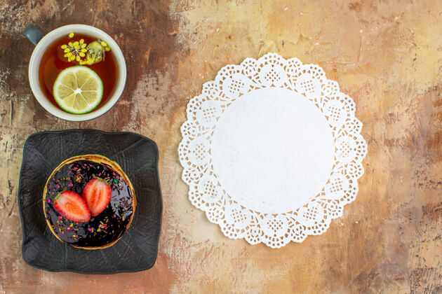 顶顶视图美味的甜煎饼和一杯茶放在一张轻便的桌子上葡萄酒茶蛋糕