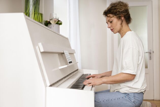 钢琴一个金发女人弹钢琴的侧视图放松里面弹钢琴