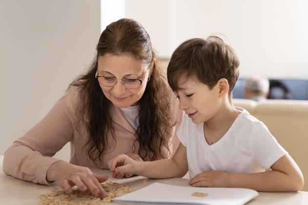 室内孙子和奶奶一起做作业女人学习孩子