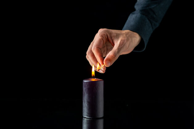 设备黑暗表面上的黑暗蜡烛照明的前视图蜡烛视图燃烧
