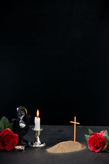 蜡烛一个小小的坟墓 上面开着红花 燃烧着蜡烛 在黑暗的表面上留下了记忆烛台葬礼死亡