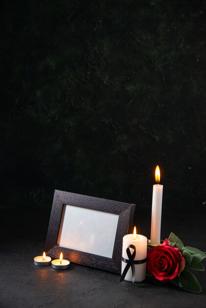 火炬在黑暗的表面上燃烧蜡烛与相框的正面视图火烛光葬礼
