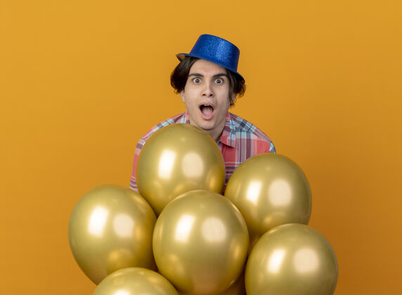 帽子高加索帅哥戴着蓝色派对帽 站着氦气球氦派对气球