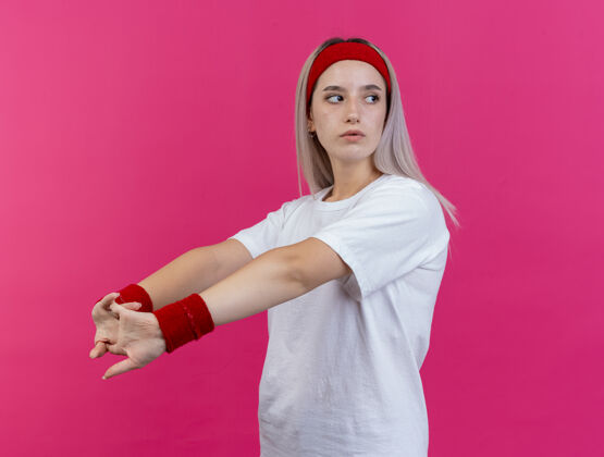 信心自信的年轻白人运动女孩戴着背带和头带年轻手伸展