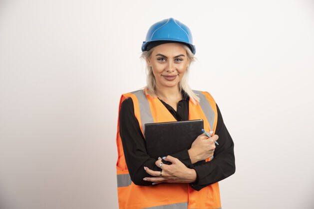 成人女建筑工人拿着笔记本站着高质量的照片女人背心笔记本