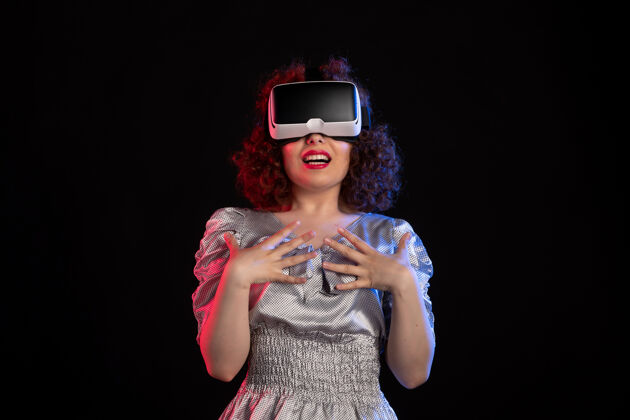游戏年轻女性戴着虚拟现实耳机在黑暗的表面肖像现实虚拟
