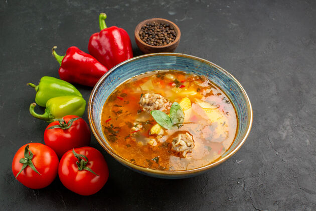 碗前视图美味的肉汤与新鲜蔬菜在黑暗的背景胡椒蔬菜汤