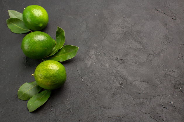 水果前视图新鲜的绿色柠檬在黑暗的背景柠檬新鲜新鲜绿色柠檬