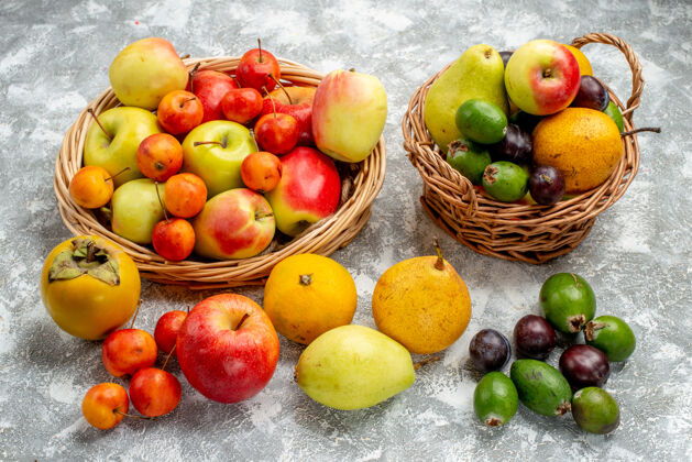 健康下图红黄相间的苹果 李子 梨 柿子在柳条筐里 也在地上营养柳条食用水果
