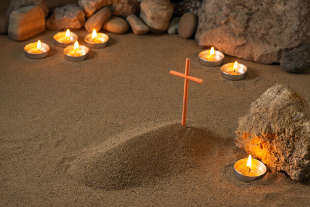 死亡小小的坟上用石头和蜡烛围绕着沙土葬死石头火火焰