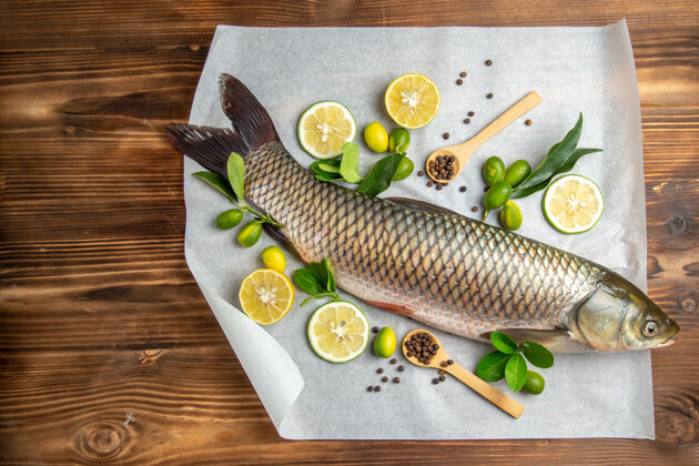 切片顶视图新鲜鱼柠檬片木桌上的食物海鲜菜海洋膳食鱼盘子