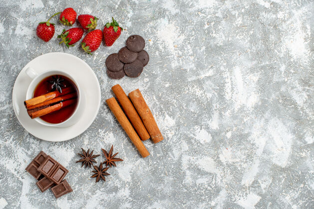 杯子俯瞰桂皮茴香籽茶和一些草莓巧克力桂皮茴香籽在桌子的左侧有自由空间草莓壁板顶部