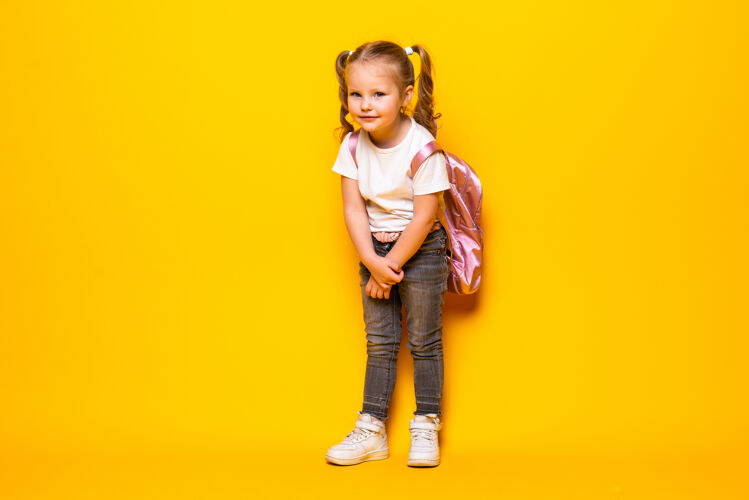 女学生黄色墙上一个带着背包微笑的小女生的画像可爱漂亮学校