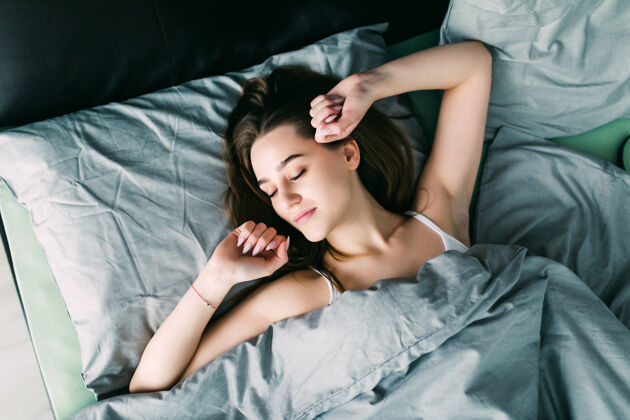 睡觉时间年轻漂亮的女人醒来时在床上充分休息醒来幸福早睡