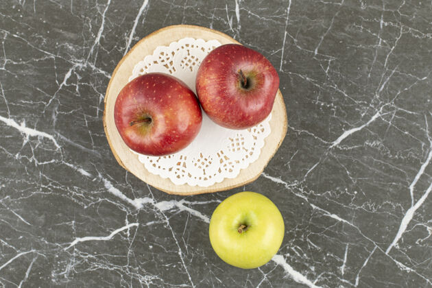 餐两个红苹果和一个绿苹果放在木板上切片成熟健康