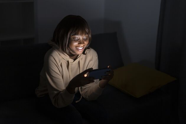 客厅笑眯眯的非洲裔美国女人在家看netflixNetflix观看用户
