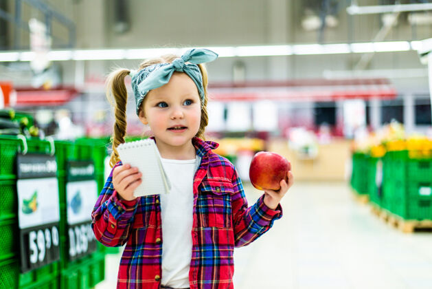 超市可爱的小女孩在超市里列购物清单小女孩杂货店孩子