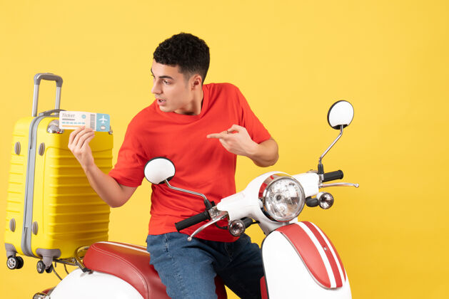 车票正面图：年轻男性 穿着红色t恤 手持车票 骑在轻便摩托车上健康正面视野