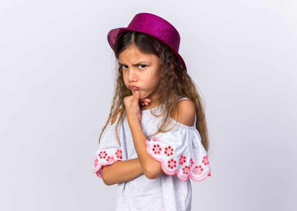 帽子恼怒的小白种女孩 戴着紫色派对帽 下巴被隔离在白色墙壁上 留着复印空间下巴女孩孤立