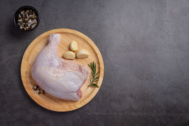 食物生鸡肉大腿放在深色的木头表面上芳香的生鸡肉饭