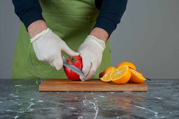 橙子男手切红苹果放在桌上的木板上男准备烹饪