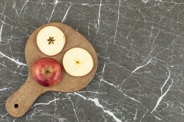 小吃新鲜红苹果的顶视图在灰色上素食餐切片