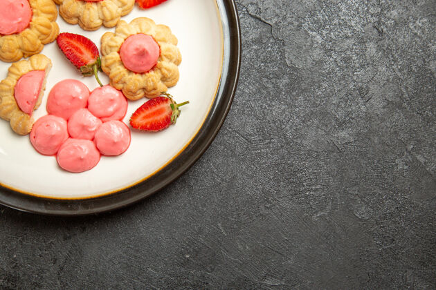 美味美味的糖饼干与草莓果冻在灰色的表面俯视图晚餐盘子草莓