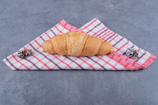 美食新鲜出炉的羊角面包放在粉色的棉质餐巾上餐厅盘子有机