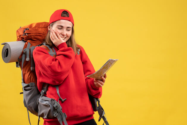 衣服正面图微笑的女徒步旅行者带着红色背包看地图快乐地图成人