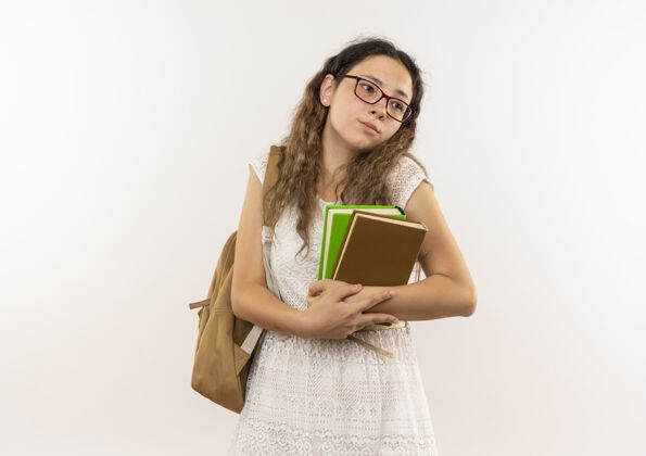 抱悲伤的年轻漂亮的女学生戴着眼镜 背着书包 看着隔离在白墙上的一面人感情脸