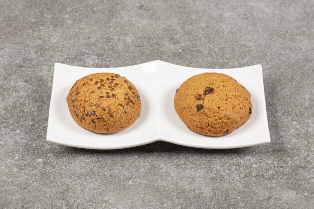 自制两个自制的新鲜饼干放在白色盘子里收藏饼干食品