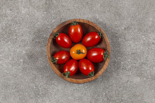 成熟的装满樱桃番茄的木碗番茄排列一半